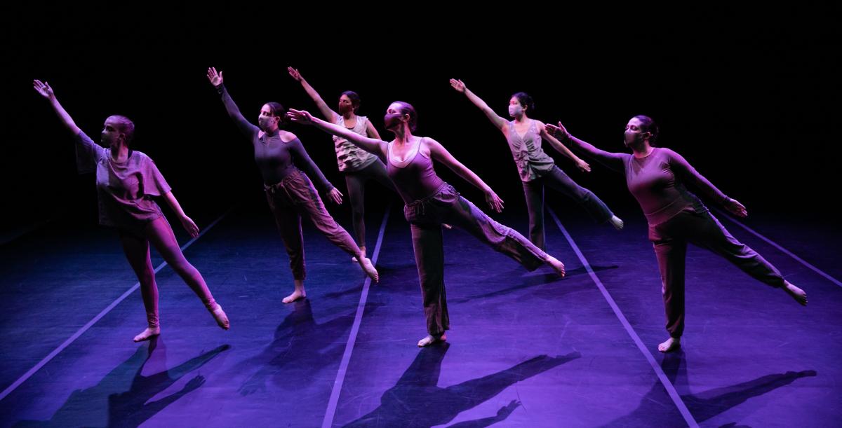 6 dancers in motion, right arms up and outstretched, leaning right, left legs lifted.